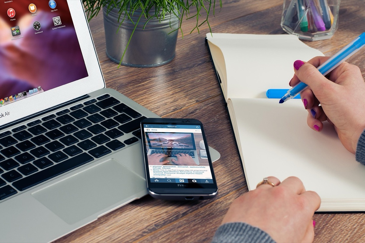 Cellulare su tavolo con laptop e quaderno