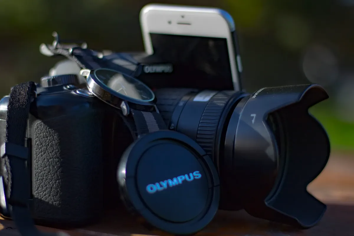 Close-up shot of an Olympus camera with accessories, ideal for photography enthusiasts.